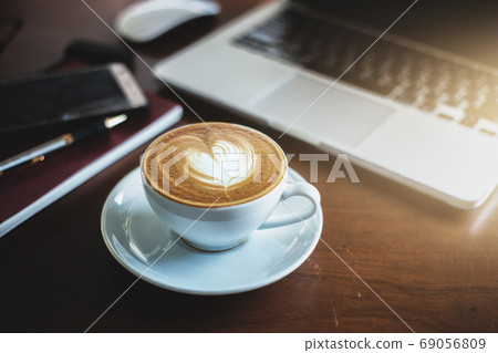 A latte coffee and laptop on the table.. A latte coffee and laptop on the table.. 69056809