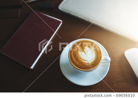 A latte coffee and laptop on the table.. A latte coffee and laptop on the table.. 69056810