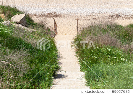 An empty trail goes down to the beach 69057685