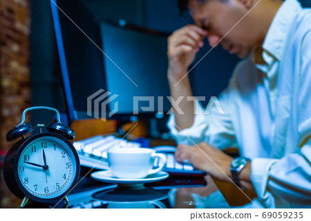 headache, tense young asian businessman working on computer at night headache, tense young asian businessman working on computer at night 69059235