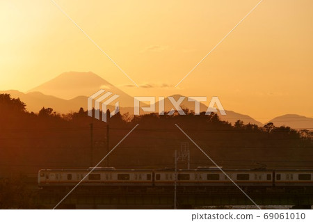 A train running behind Fuji in the evening glow 69061010