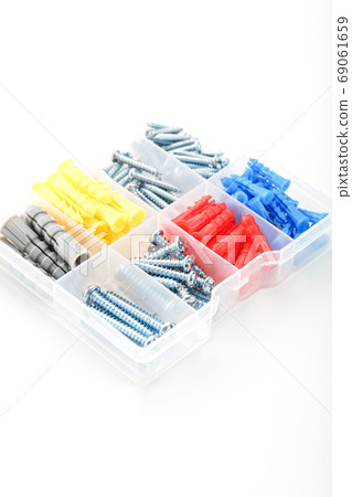 Box with screws and dowels of different sizes, shapes and colors on a white background. Box with screws and dowels of different sizes, shapes and colors on a white background. 69061659