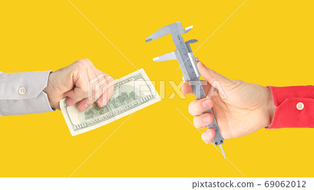 hands with work tool and money on a orange background. salary. b hands with work tool and money on a orange background. salary. b 69062012