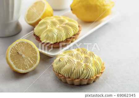 Tartlets with lemon cream on a white table. Tartlets with lemon cream on a white table. 69062345
