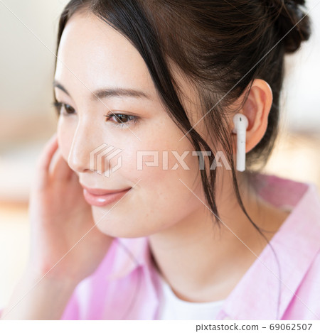 方形的戴著無線耳機的微笑的年輕女子的臉 69062507
