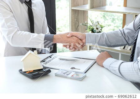 Real estate agent are shaking hands after good Real estate agent are shaking hands after good 69062612