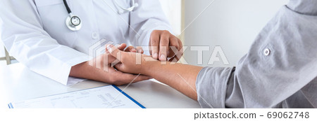 Doctor checking measuring pressure on patient's Doctor checking measuring pressure on patient's 69062748