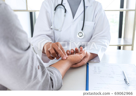 Doctor checking measuring pressure on patient's Doctor checking measuring pressure on patient's 69062966