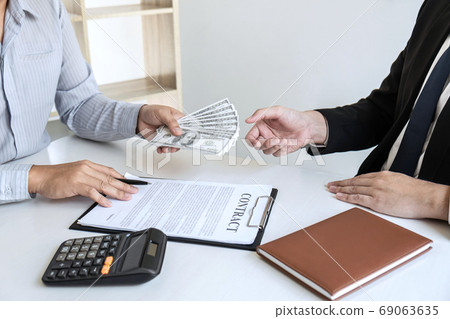 Businessman giving bribe money in the envelope of 69063635