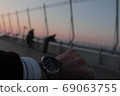 A man waiting at the airport deck while worrying about the time 69063755