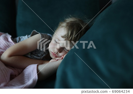 Little girl sleeps in her bed in bedroom. 69064234