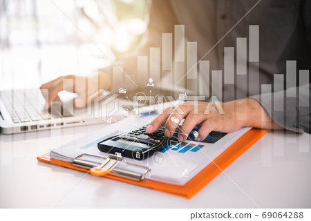 Businessman working with calculator, business document and laptop computer notebook at home office. Businessman working with calculator, business document and laptop computer notebook at home office. 69064288