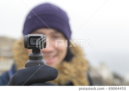 A man travels and takes off everything seen on the action camera .Focus on action camera.Winter. 69064450