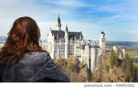 A girl looking at castle Neuschwanstein A girl looking at castle Neuschwanstein 69065082