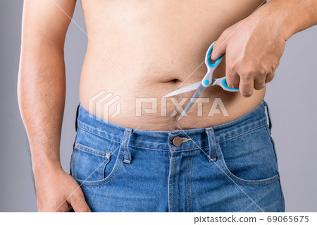 Portrait man using scissors to cutting body hair. Studio shot on 69065675