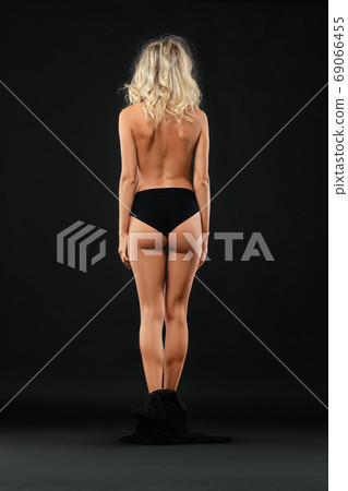 Pretty lady with long blond hair undressing in black lingerie 69066455