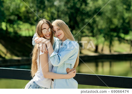 Two young women hugging each other 69066474