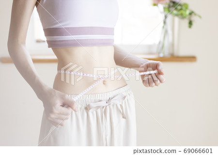 A woman measuring the waist A woman measuring the waist 69066601