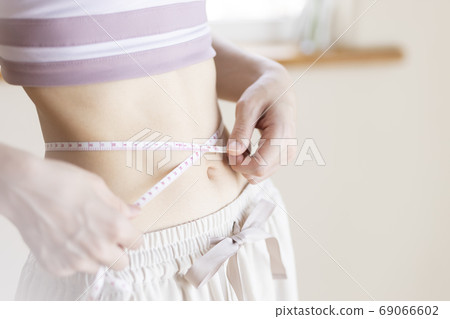A woman measuring the waist 69066602