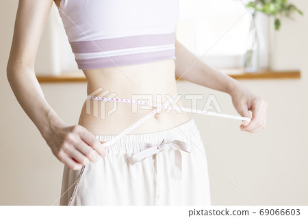 A woman measuring the waist A woman measuring the waist 69066603