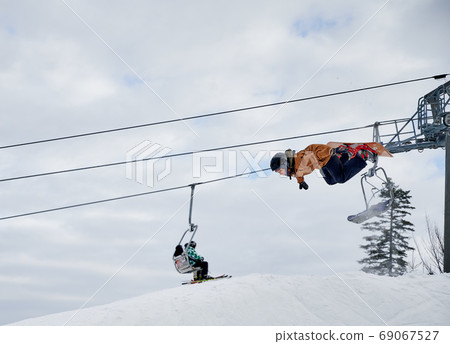 Winter kinds of sport. Skier doing tricks in the mountains in winter season Winter kinds of sport. Skier doing tricks in the mountains in winter season 69067527