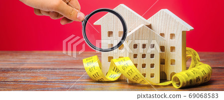 Miniature wooden houses and measuring tape. Home appraisal and property valuation concept. Housing construction, repair and maintenance. Real estate appraiser 69068583