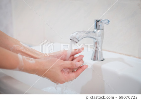 Woman washing hands, Corona virus travel prevention wash hands with soap and hot water. Hand hygiene for coronavirus outbreak. Protection by washing hands frequently concept. 69070722