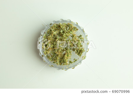 Cannabis in grinder top view isolated Cannabis in grinder top view isolated 69070996