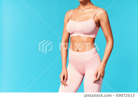 Cropped image of fit woman torso on blue background with copy space 69072013