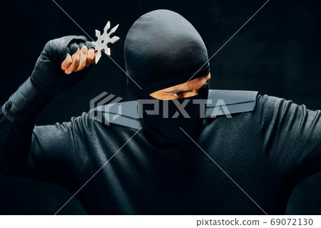Ninja with a sword and shuriken ready to stab enemy 69072130