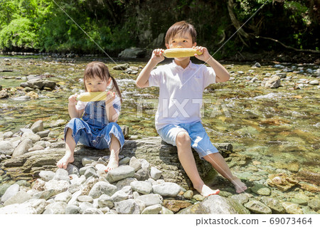 Brother and sister eating corn in Kawahara 69073464