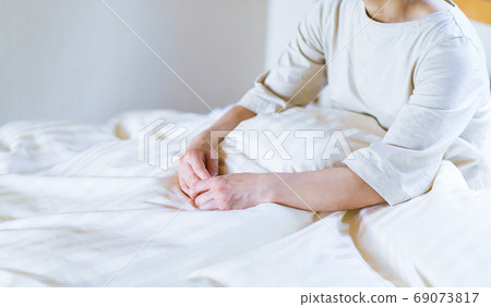 A middle-aged woman who is waking up in the early morning of summer and feels tired due to lack of sleep [lifestyle] 69073817