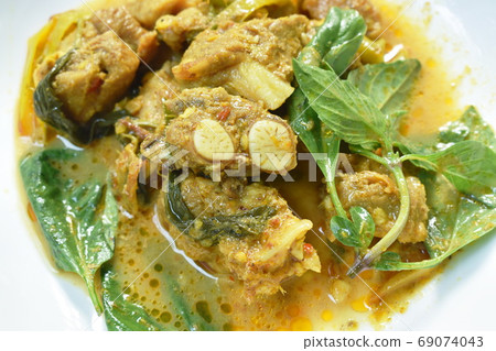 spicy fried pork bone with slice finger root in curry sauce on plate spicy fried pork bone with slice finger root in curry sauce on plate 69074043