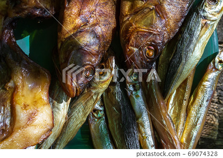 smoked fish perch, capelin on an old wooden table, top view smoked fish perch, capelin on an old wooden table, top view 69074328