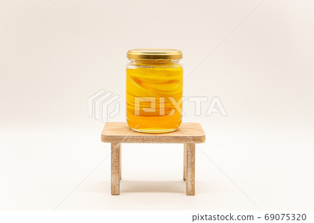 Bottled honey lemon on a table Bottled honey lemon on a table 69075320
