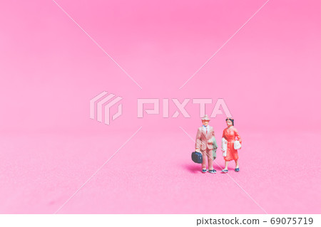 Miniature people Couple of travellers on pink background 69075719