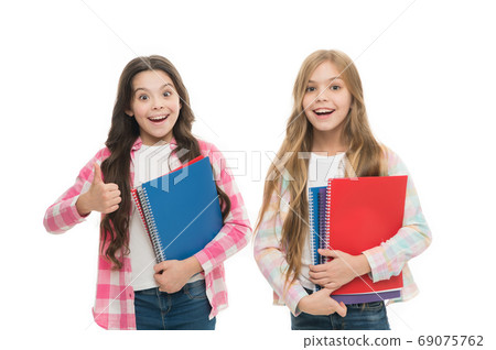 Recommending the books. Small girls giving thumbs up for school activity books. Little children  69075762