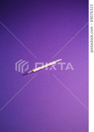 Analog thermometer on violet purple background Analog thermometer on violet purple background 69076323
