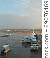 Jet plane loading luggage at the airport after rain 69076469