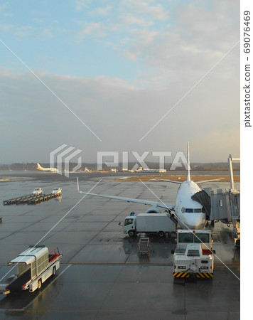 Jet plane loading luggage at the airport after rain 69076469
