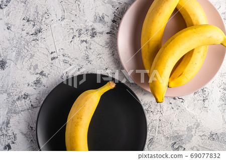 Banana fruits in pink and black plates 69077832