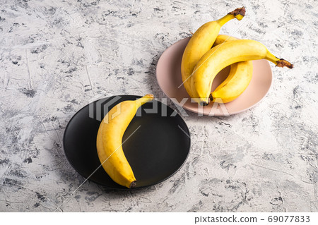 Banana fruits in pink and black plates 69077833