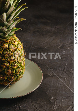 Fresh sweet pineapple in grey plate Fresh sweet pineapple in grey plate 69077912