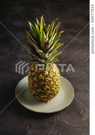 Fresh sweet pineapple in grey plate Fresh sweet pineapple in grey plate 69077914