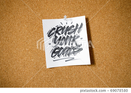 Crush your goal, motivational text written on reminder sticky note pinned on cork board Crush your goal, motivational text written on reminder sticky note pinned on cork board 69078580