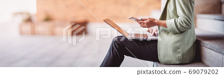 young woman with laptop sitting on the stairs young woman with laptop sitting on the stairs 69079202