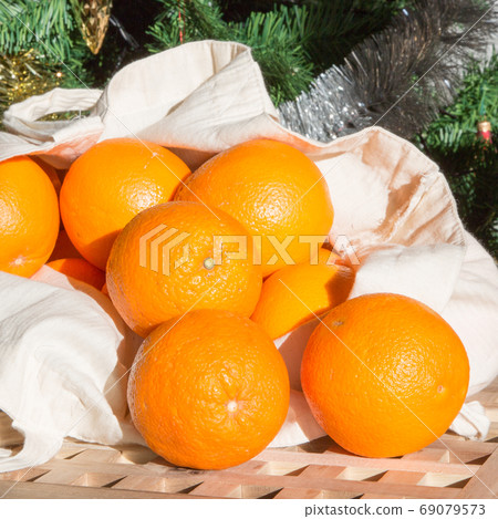 Christmas holiday still life with close up fresh raw oranges rolling out of the shopping bag 69079573