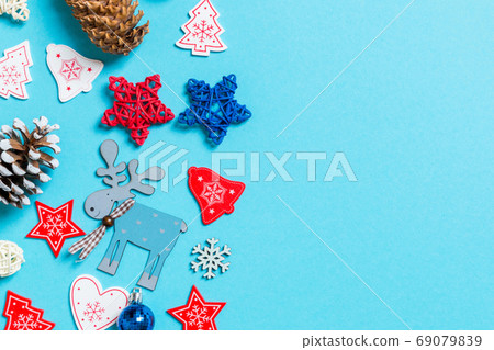 Top view of New Year toys and decorations on blue background. Christmas time concept with empty space for your design Top view of New Year toys and decorations on blue background. Christmas time concept with empty space for your design 69079839