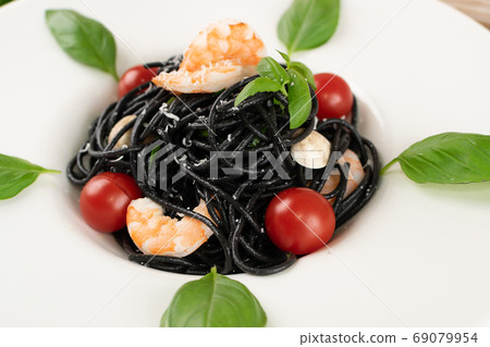 Black Spaghetti with Shrimps on White Restaurant Plate 69079954