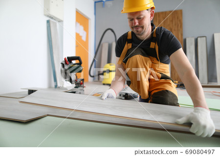 Specialist hold laminate in his handand put it on floor. Specialist hold laminate in his handand put it on floor. 69080497